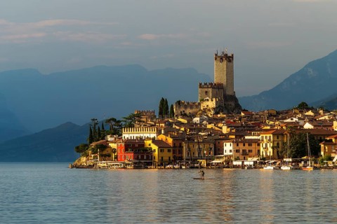 Scaliger castle and city malchesine at sunset with stand up paddle