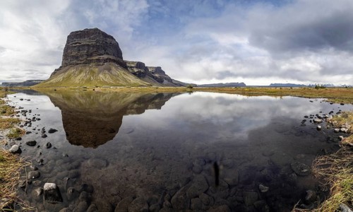 Rock massif Lomagnupur or Lómagnúpur, reflection in a pond, panoramic photo, South Iceland,