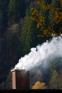 Smoking chimney of a residential building. Exhaust fumes and environmental protection Austria