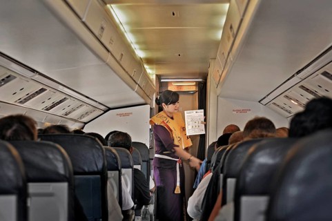 Flight attendant, obsolete stewardess explaining the function of the life jacket, propeller