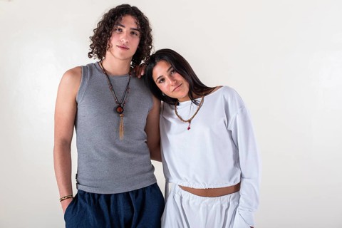 Portrait of a young couple dressed in yoga clothes looking ti the camera white background. Studio