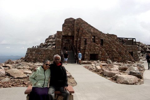 Old man and woman sitting in front of Crest House built in 1939