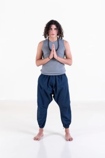 Young man clasping hands while looking at camera over white background. Meditation concept. Studio