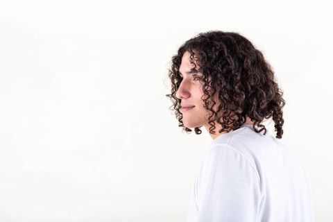 Portrait of a young man dressed in white yoga clothes over white background. Studio shot. Copy