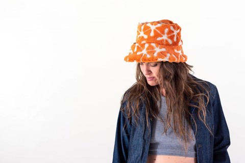 Portrait of a woman looking down, wearing a hat over a white background. Copy Space. Studio Shot