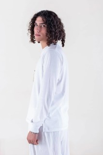 Portrait of a young man dressed in white yoga clothes over white background while looking at camera