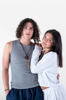 Portrait of a young couple dressed in yoga clothes looking ti the camera white background. Studio