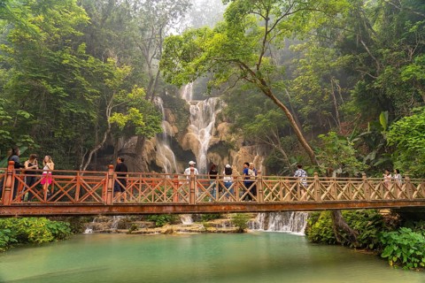 Tourists on the bridge at Kuang Si waterfall near Luang Prabang, Laos, Asia