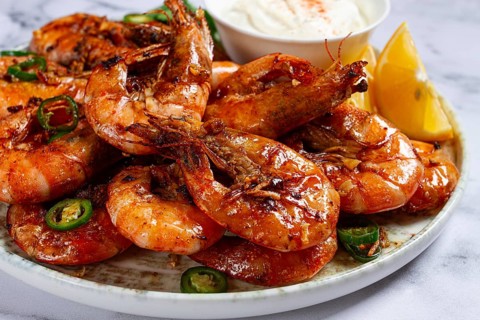 Grilled shrimps served with hot sauce and slices of fresh lemon, homemade, no people