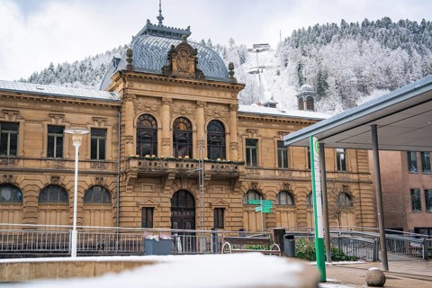 Historic building with snow-covered architecture and surrounding mountain panorama in winter, Bad