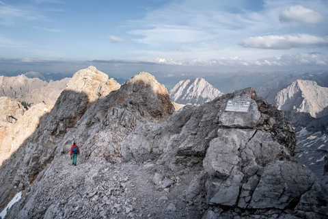 Mountaineer on a ridge, jubilee ridge in the evening light, sign, signpost, steep rocky mountain