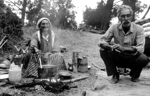 Woman and man Woman cooking outside with firewood in the Peloponnese, Greece, Europe