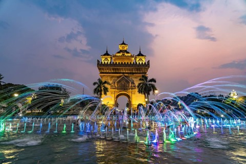 Colourfully illuminated fountain at Patuxai Victory Gate at dusk, capital Vientiane, Laos, Asia