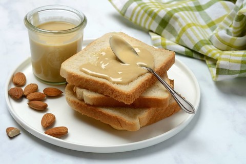 Almond cream on toast, almonds and spoon