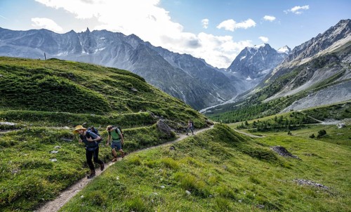Mountaineer on a hiking trail, mountain landscape near Arolla, behind mountain peak Mont Collon,