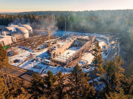 Construction site near domed buildings in the forest, snow-covered and with construction crane, new
