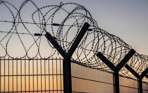 Symbolic image security, S-wire rolls, NATO wire, on a fence top, demarcation of a property,