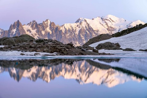 Evening mood with pink evening sky, mountain landscape at sunset, water reflection in Lac Blanc,