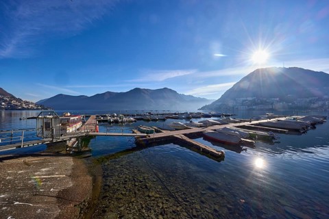 Marina, motorboats, lake, mountains, haze, backlight of the sun, blue sky with veil clouds, Lake