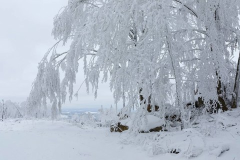Rock formation with hoarfrost and snow on the summit of the Czorneboh with a view of the Lusatian
