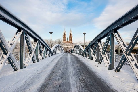 Bridge with snow and ice and cyclists, Blue Bridge and Stühlinger Church, Freiburg im Breisgau,