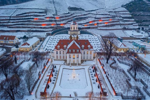 Aerial view of Wackerbarth Castle with castle park, belvedere and vineyards with snow and Christmas