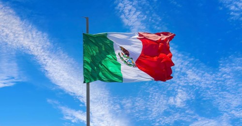 Los Cabos, Mexico, Mexican tricolor national striped flag proudly waving at mast in the air with