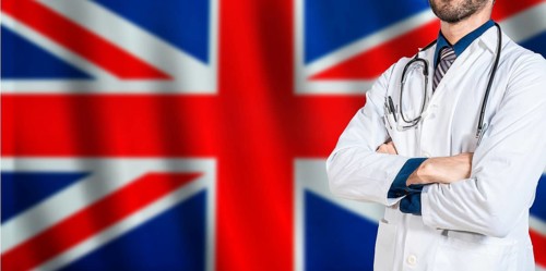 Doctor with crossed arms on British flag. UK Health and Care concept. Professional doctor on