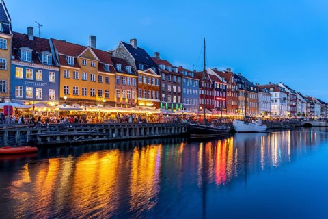 Colourful houses, restaurants and historic ships on the Nyhavn canal and harbour at dusk,