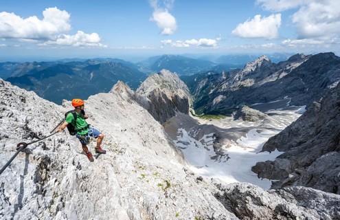 Mountaineer with helmet in a secured via ferrata, Zugspitze via ferrata, ascent to the Zugspitze,