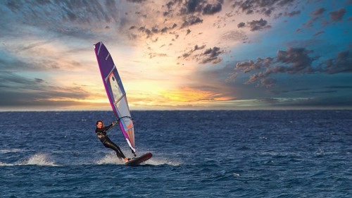 Sky exchanged, windsurfer enjoying the movement of the water at sunset, windsurfer, Meltemi