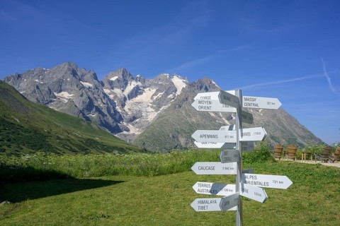 Signpost behind Pointe Piaget and La Meije seen from the botanical garden Jardin du Lautaret,