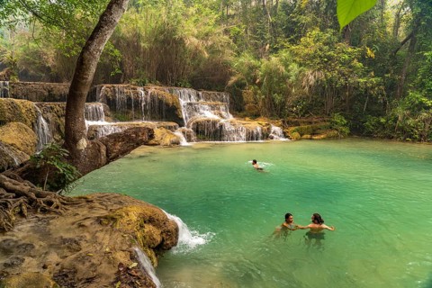 Tourists bathing in the Kuang Si waterfall near Luang Prabang, Laos, Asia