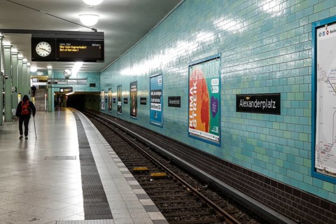 A man with a walking stick on an empty platform at Alexanderplatz underground station, Berlin,
