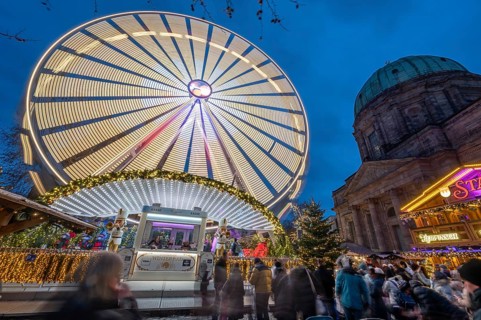 Ferris wheel at the winter village, Christmas market at dusk, St Elisabeth's Church on the right,