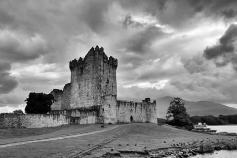 Ross Castle ruins on Lough Leane, dramatic evening sky, rain clouds, monochrome, Killarney National