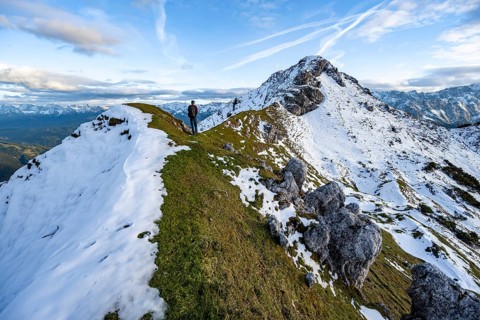 Mountaineer on hiking trail, mountain landscape with snow in autumn, summit and ridge of the