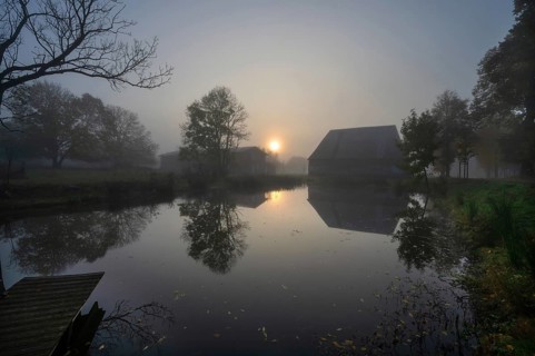 Morning sun over the estate pond on a foggy morning at Gut Othenstorf, Othenstorf near Rehna,