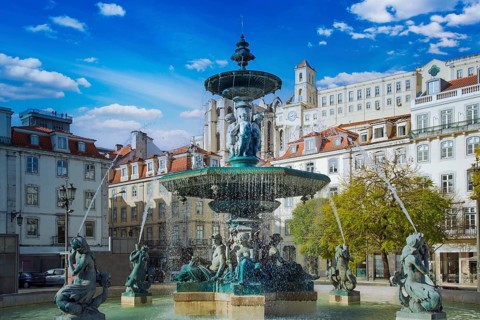 Lisbon, Rossio Square fountain and colorful historic buildings of historic city center