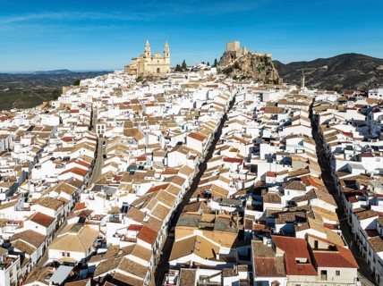 The hilltop White Town of Olvera with its La Encarnación church and Moorish castle. Aerial view.