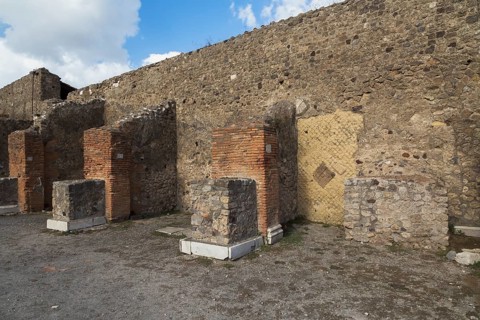Remnants of old terracotta brick and stone wall structure plus numbered columns with white marble