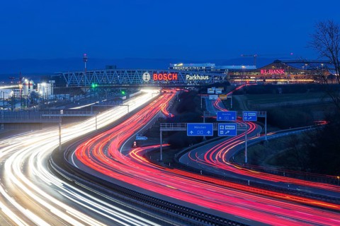 A8 motorway at Stuttgart Airport in the evening. Heavy traffic, lanes of light. Modern architecture