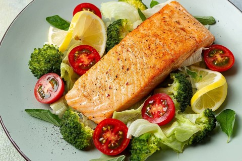 Grilled salmon fillet, with vegetables, broccoli, cherry, iceberg lettuce, spices and herbs,