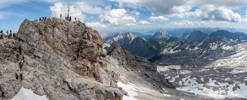 Tourists queue up for the summit of the Zugspitze, summit with golden summit cross, overtourism,
