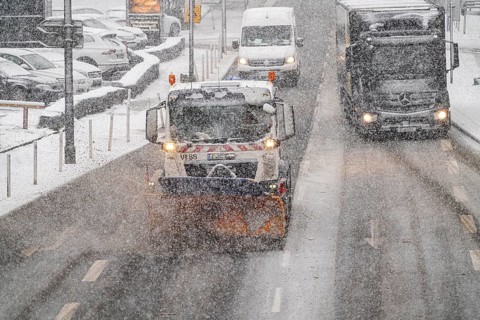 Winter weather, heavy snowfall, city centre traffic, winter service vehicle from