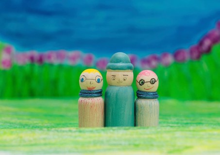 Three funny painted wooden cones in front of a painted background, North Rhine-Westphalia, Germany,