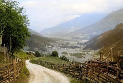 Country road lane leading to villages rural settlement in Alpine mountain valley Tyrol, Austria,