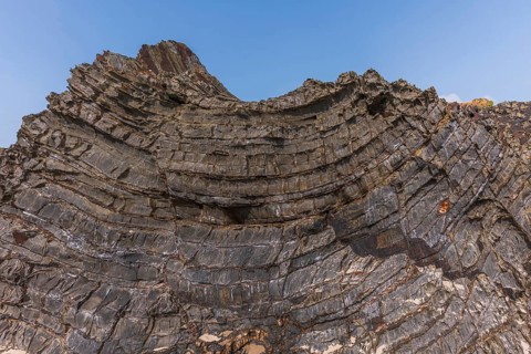 A rock with many holes and caves. Strange shapes in volcanic rock. Crozon, Brittany, Finistere,