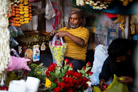 Vendor makes rose bouquet to sell in a street flower shop, on the occasion of Valentines day on