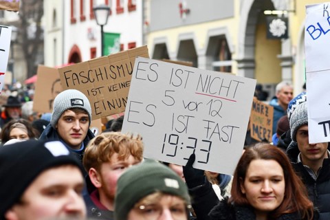 Heidelberg, Germany - February 12th 2025: People holding up signs in crowd at protest against